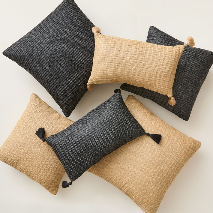 four black and tan pillows with tassels on the sides, all in different sizes