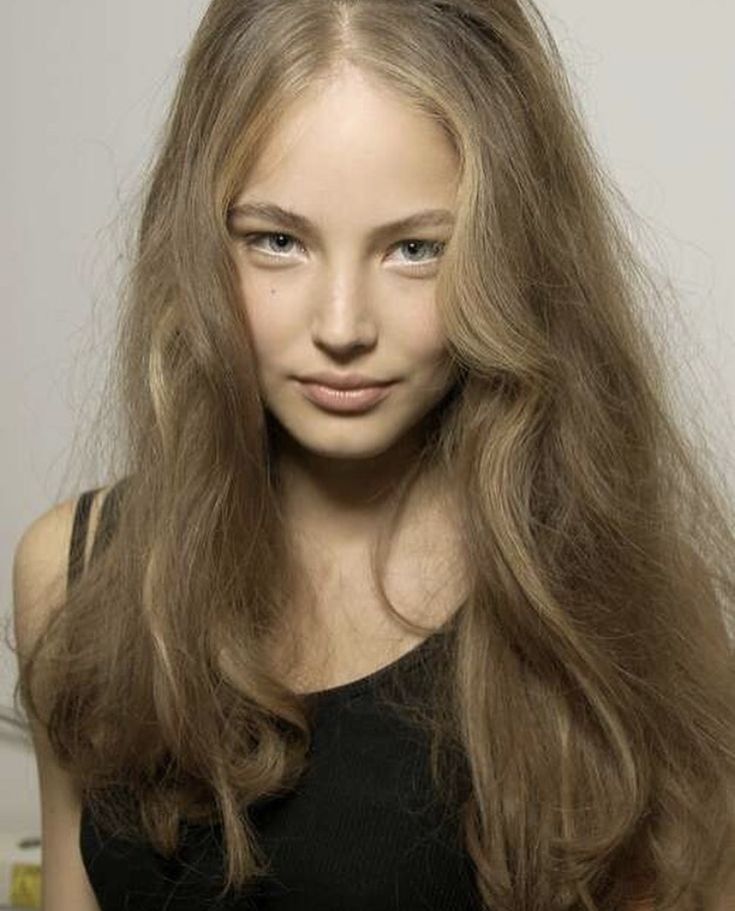 a woman with long hair is posing for the camera