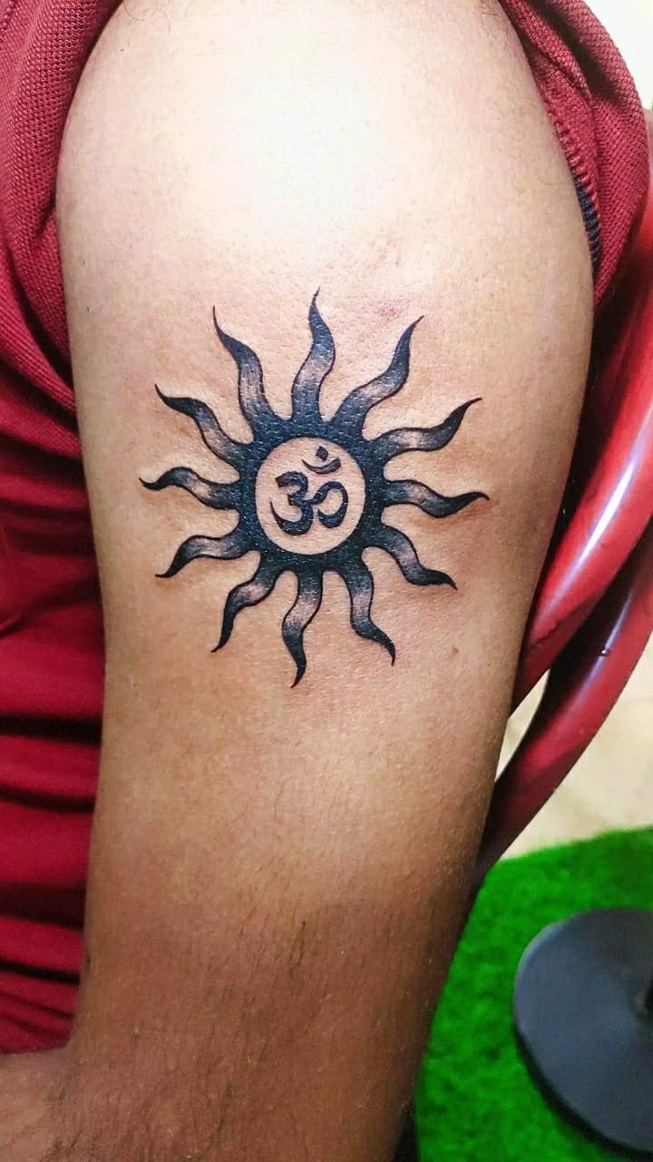 a man with a sun tattoo on his arm