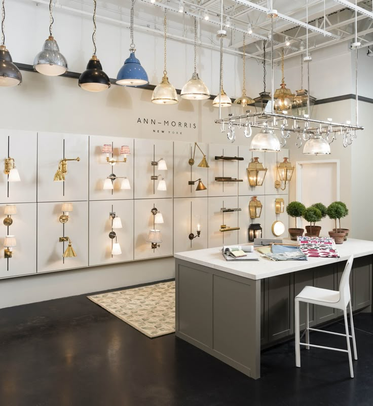 a room filled with lots of lamps and lights hanging from the ceiling next to a table