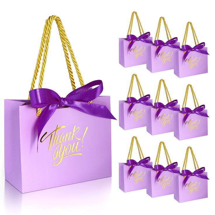 purple gift bags with gold foil lettering and a purple ribbon tied around the handles that say thank you