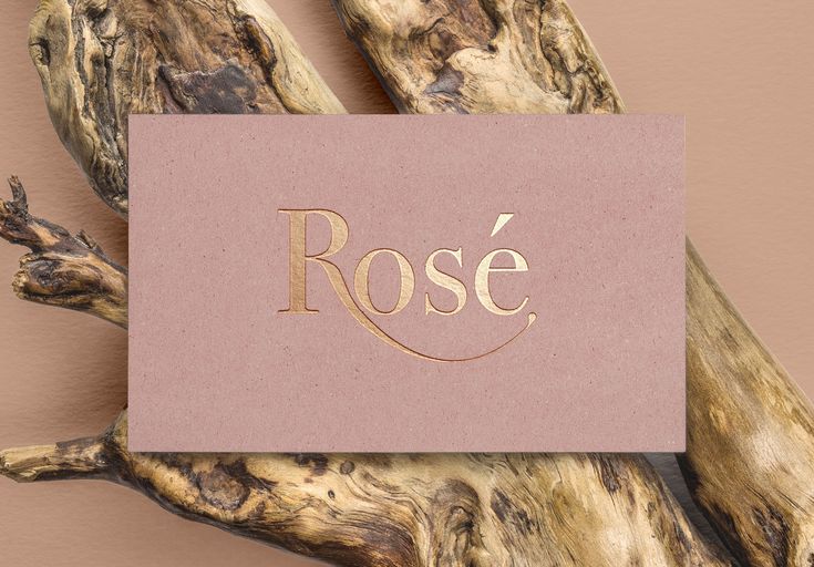 a piece of paper with the word rose on it sitting on top of a tree branch