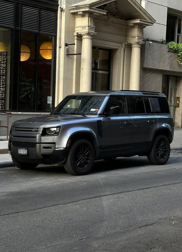 an suv is parked on the street in front of a building