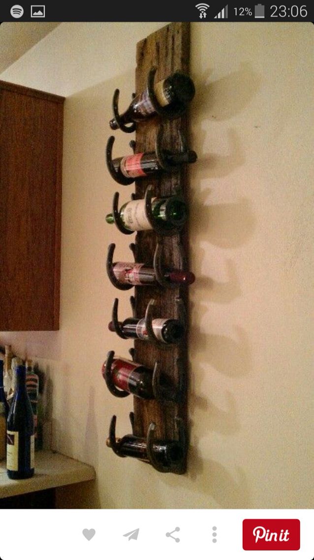 a wine rack made out of wood with several bottles hanging from it's sides