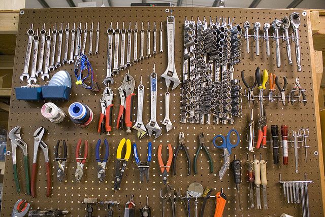 there are many tools on the pegboard in this garage wall hanging from the ceiling