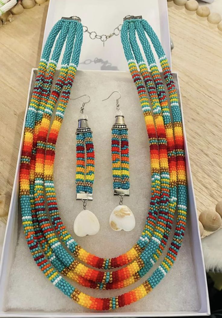 a set of multicolored beads and earrings in a white box on a table