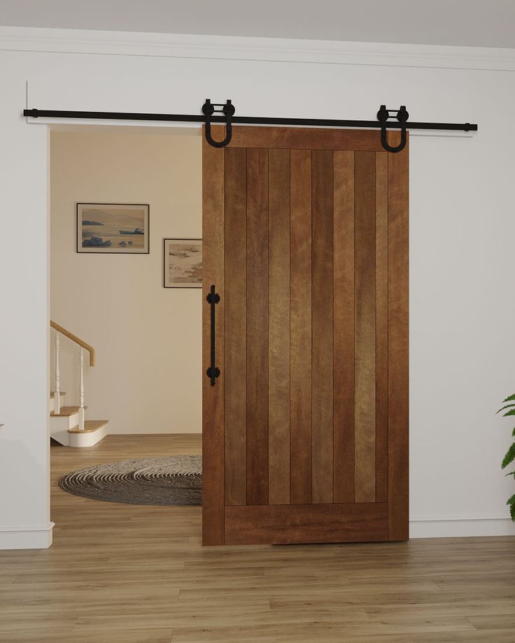 an open wooden door in a white room with wood flooring and rug on the floor