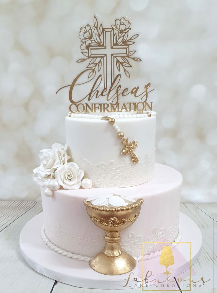 a white cake with gold decorations and a cross on top