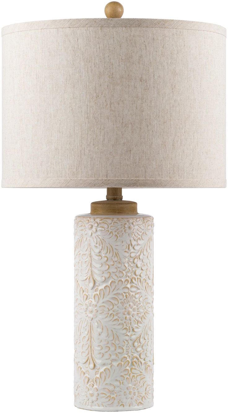 a white table lamp with a beige shade on the base and a light brown drum