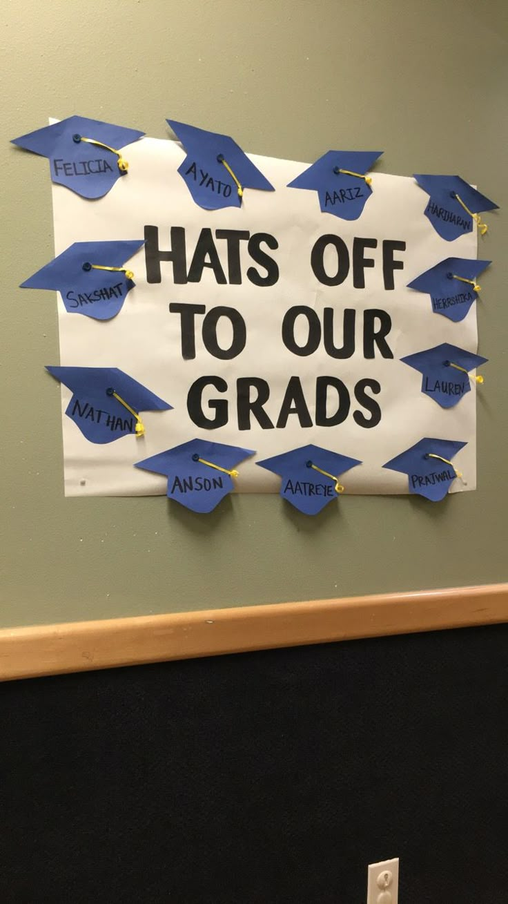 a sign that says hats off to our grads hanging on the wall in an office