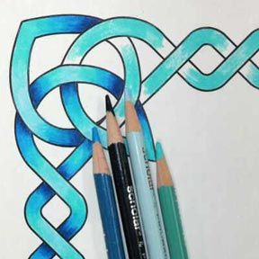 two pencils sitting next to each other in front of an intricate design on paper