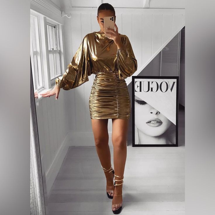 a woman taking a selfie in a gold dress