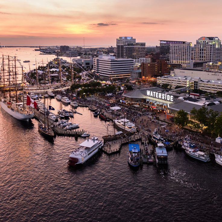 a harbor filled with lots of boats next to tall buildings