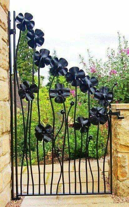 an iron gate with black flowers on it