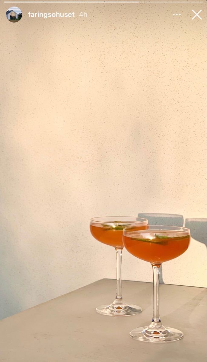 two glasses filled with liquid sitting on top of a table