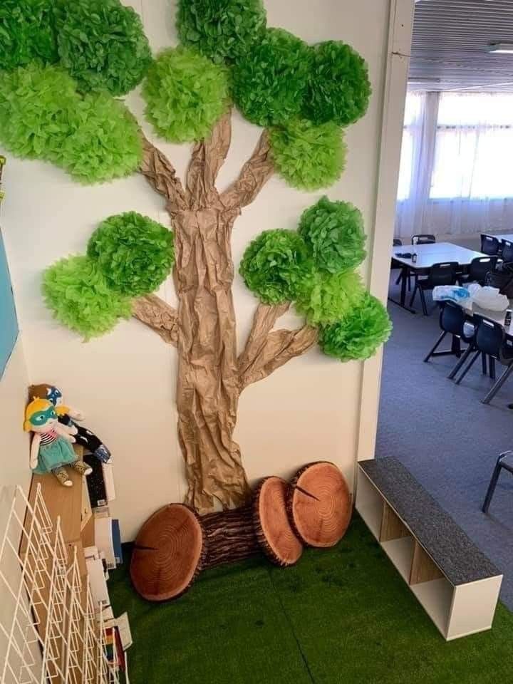 an office decorated in green and white with a tree on the wall next to it