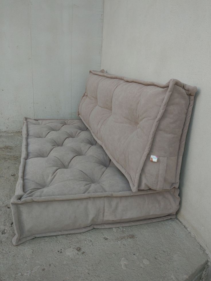 a mattress that is sitting on the ground in front of a wall with a tag attached to it