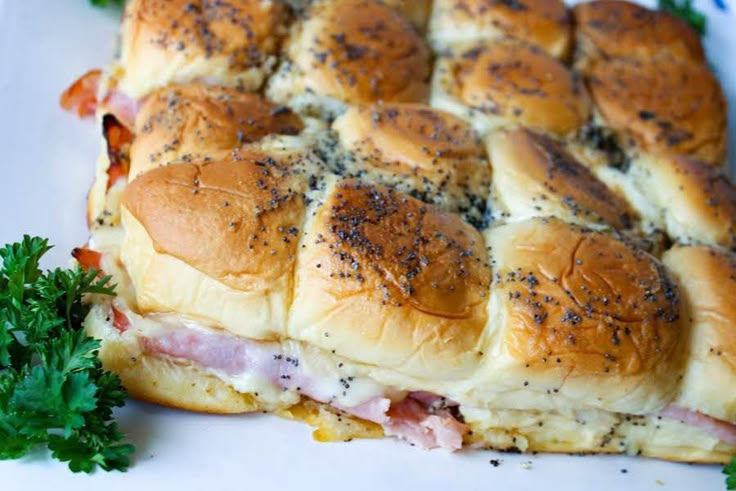 ham and cheese sliders on a plate with parsley garnish around the edges