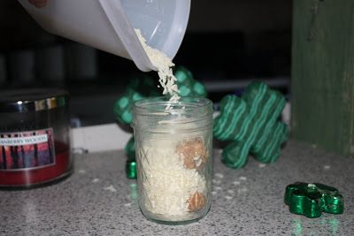 a person pouring something into a jar on top of a counter next to green candy