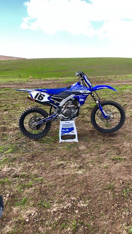 a dirt bike is parked in the middle of a field with no one around it