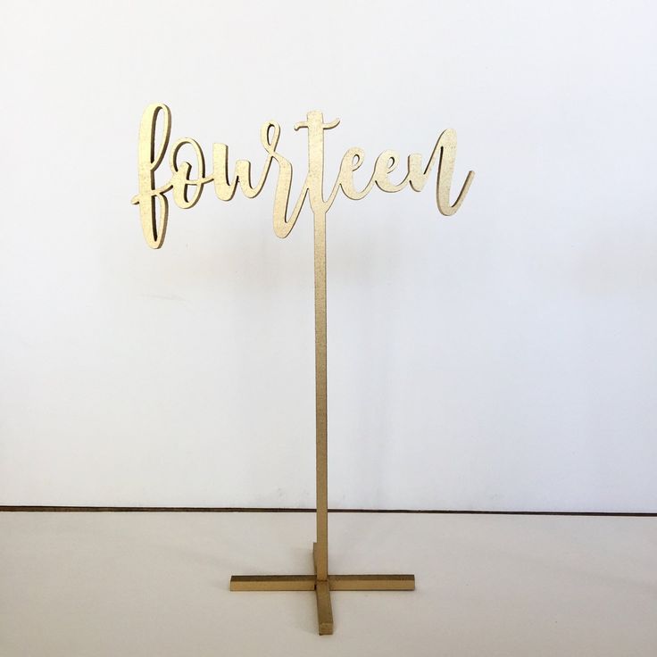 a gold cake topper with the word for fifteen on it in cursive writing