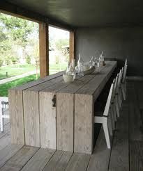 a long table with white chairs and bottles on it in the middle of a room