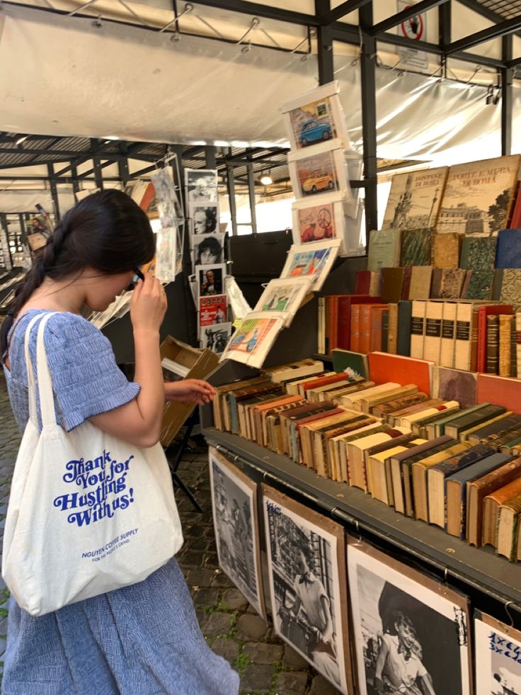 a woman standing in front of a book stand with books on the shelves and holding a phone to her ear