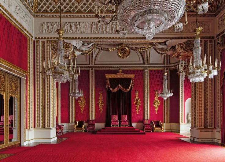 an ornate room with red carpet and chandeliers