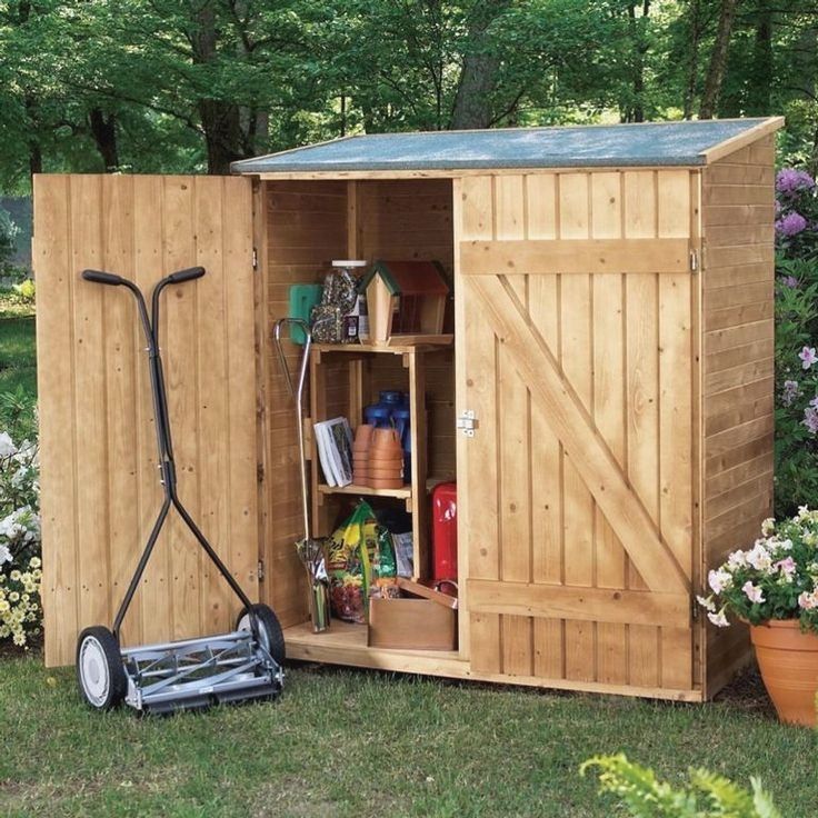 a garden shed with its door open and gardening tools in the storage area next to it