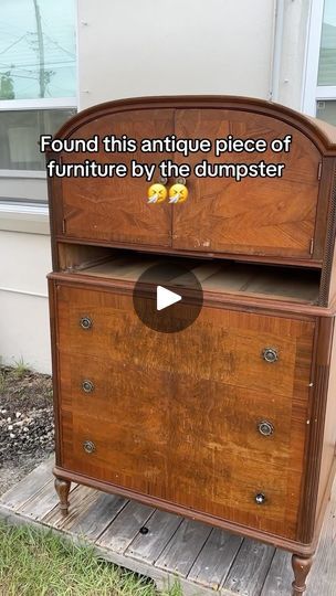 an antique piece of furniture by the dumpster