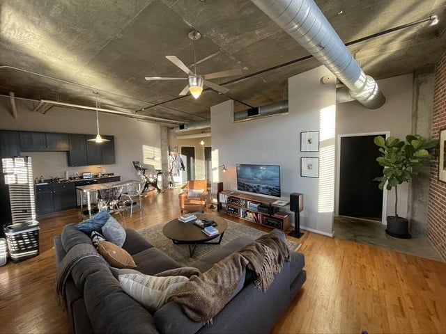 a living room filled with furniture and a flat screen tv on top of a hard wood floor