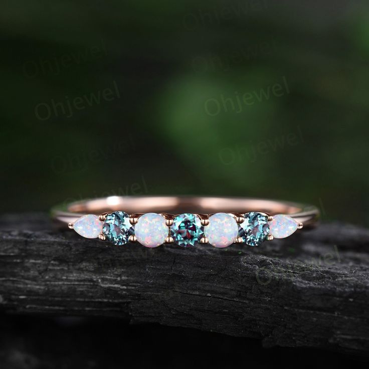 three stone ring in rose gold with blue topazte and white opal stones