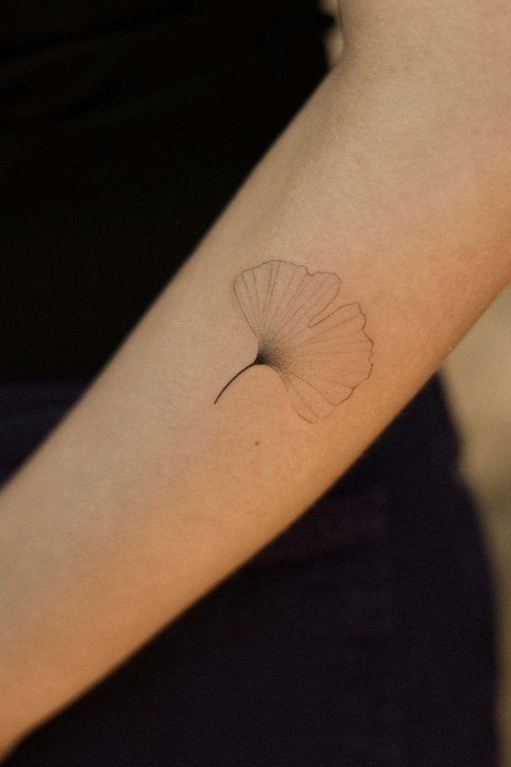 a woman's arm with a small white flower on the left side of her arm