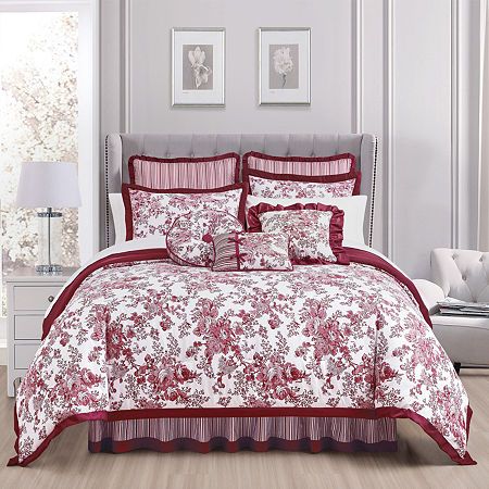 a bed with red and white comforters in a room