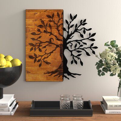 a wooden table topped with two vases filled with lemons next to a painting on the wall