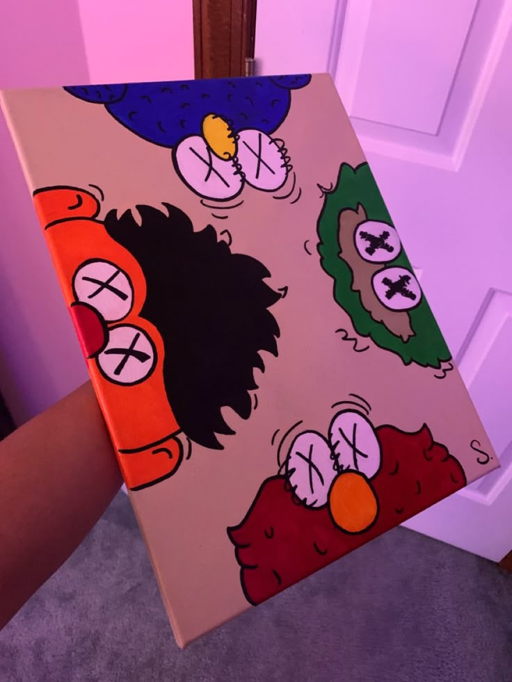 a person holding up a painting with cartoon characters on it