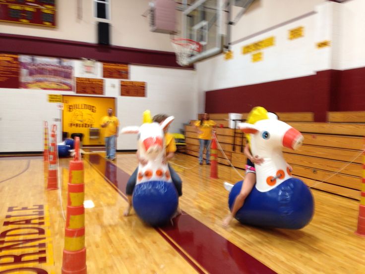 two children are riding on inflatable animals at the gym