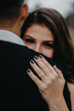 a man and woman embracing each other with their hands together