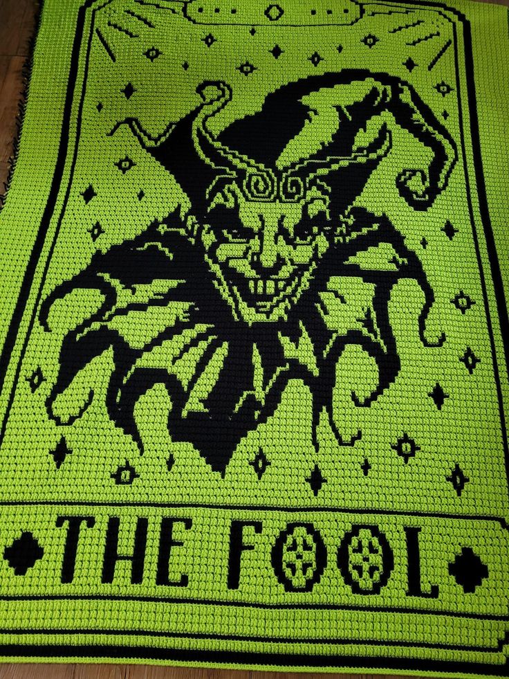 a green rug with an image of a demon on it and the words, the fool