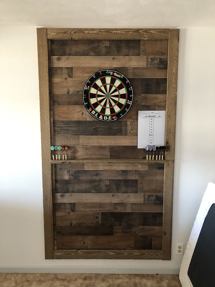 a dart board mounted to the side of a wooden door with darts on it's back