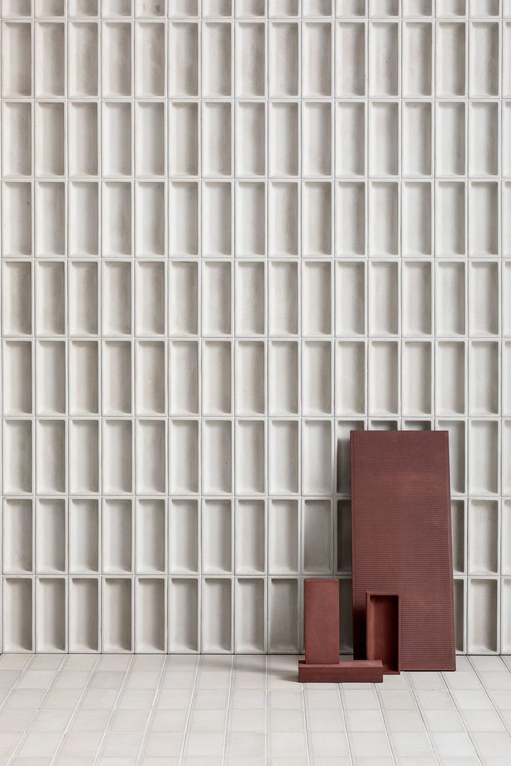 a red sculpture sitting on top of a white tiled floor