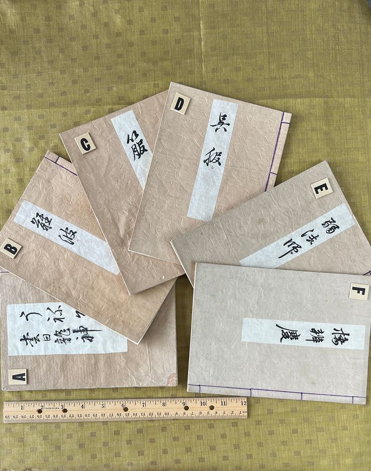 five envelopes with chinese writing on them next to a ruler and measuring tape in the foreground