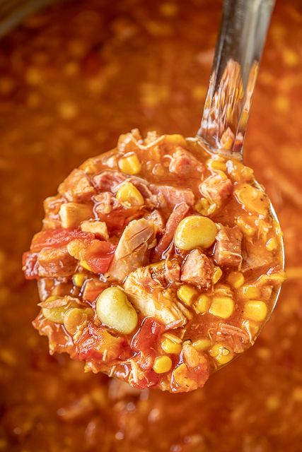 a spoon full of chili and corn soup