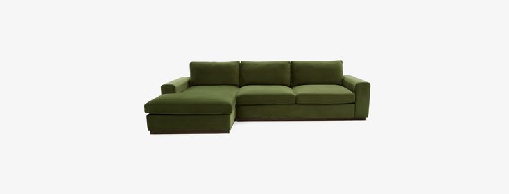 a green couch and ottoman sitting on top of a white floor next to each other