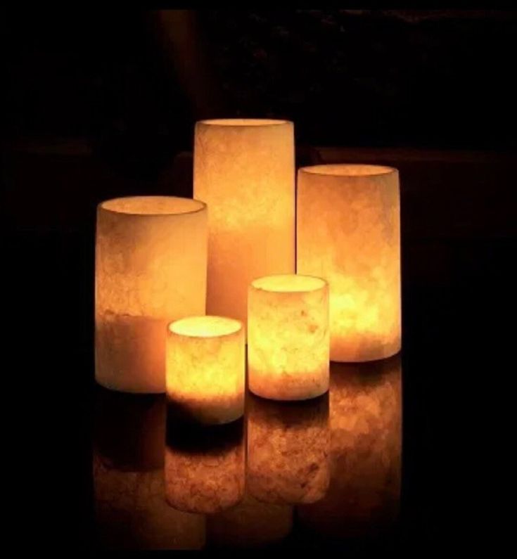 five lit candles sitting on top of a table