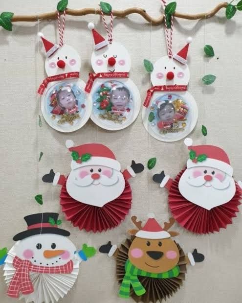 christmas decorations hanging on a wall with santa claus and snowman paper plates attached to it