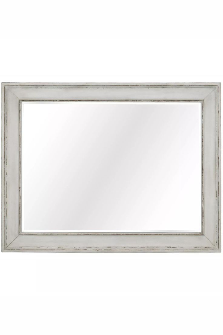 a white framed mirror on a wall with an aged wood frame and silver trimming