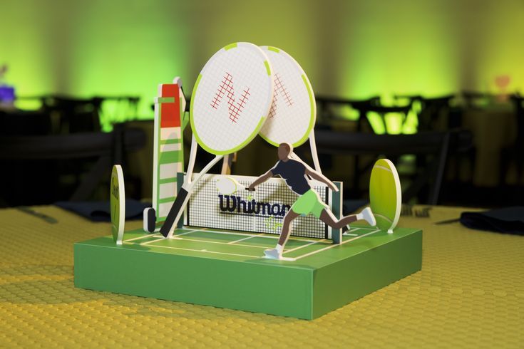 a paper model of a tennis player hitting the ball with his racket on a table