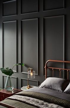 a bedroom with black walls and a metal bed frame in the middle, along with two nightstands on either side