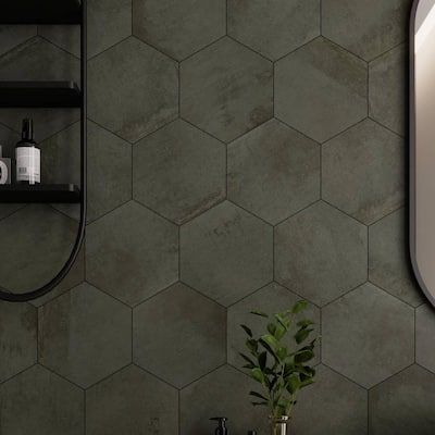 a bathroom with hexagonal tiles on the wall and a potted plant next to it